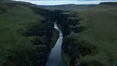 Aerial-view-from-Fjaðrárgljúfur-canyon-in-the-highlands-of-Southeast-Iceland-in-the-summer,-with-a-100-m-deep-and-2-km-long-surrounded-by-an-exotic-green-vegetation