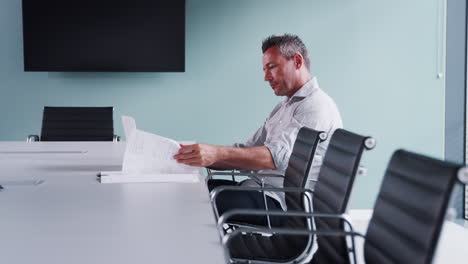 Seitenansicht-Eines-Leger-Gekleideten-Reifen-Geschäftsmannes,-Der-Am-Laptop-Am-Sitzungstisch-Im-Besprechungsraum-Arbeitet,-Aufgenommen-In-Zeitlupe