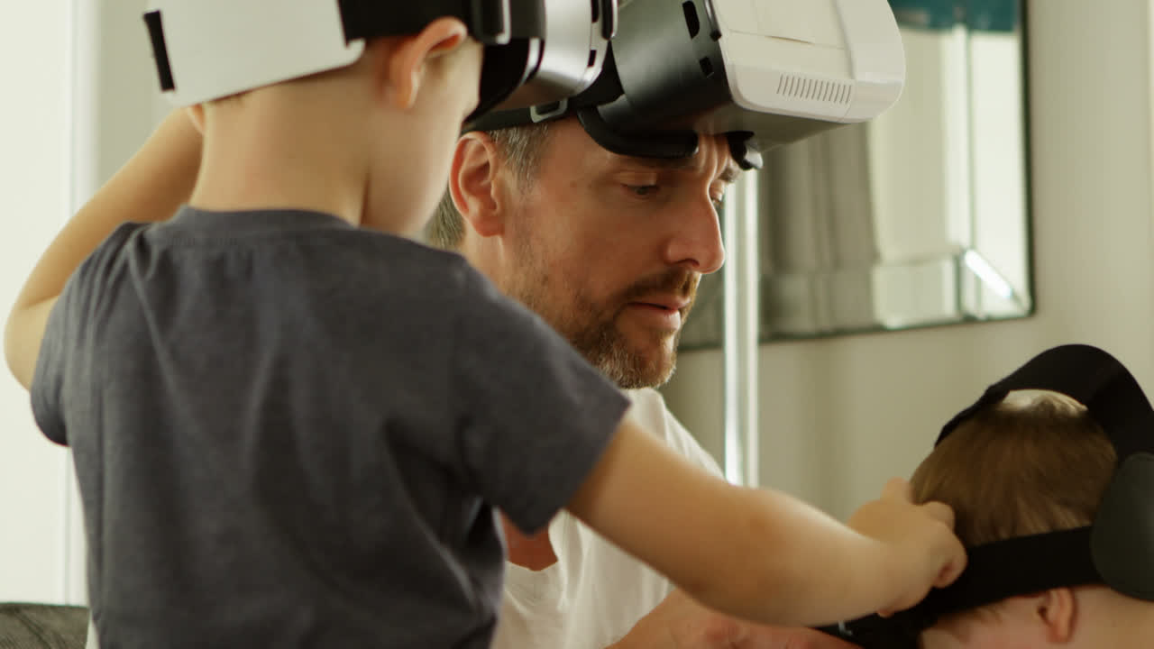 padre e hijos usando auriculares de realidad virtual en casa 4k