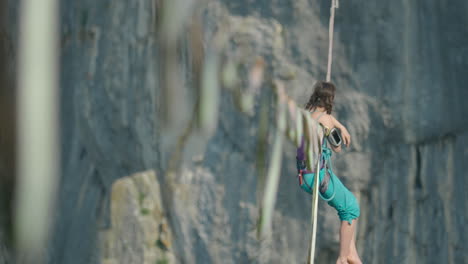 athlete on slack line high line over high cliff in extreme sport