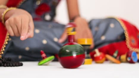 closeup of child's hands playing with a wooden roly-poly toy doll at home