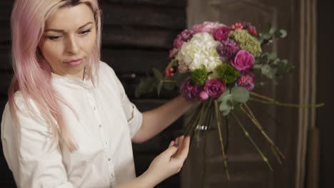 the girl florist is concentrated on a bouquet arranging. collection of beautiful, fashionable flowers. process