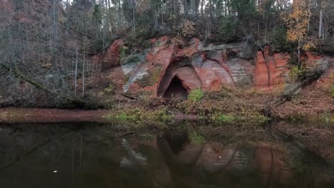 Cueva-De-Los-ángeles,-Un-Acantilado-De-Arenisca-Roja-En-Forma-De-Alas-De-ángel,-En-El-Río-Salaca-En-El-Parque-Natural-Skanaiskalns-En-Mazsalaca,-Letonia,-Tiempo-De-Otoño