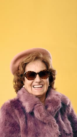 portraits of a stylish senior woman in a pink fur coat
