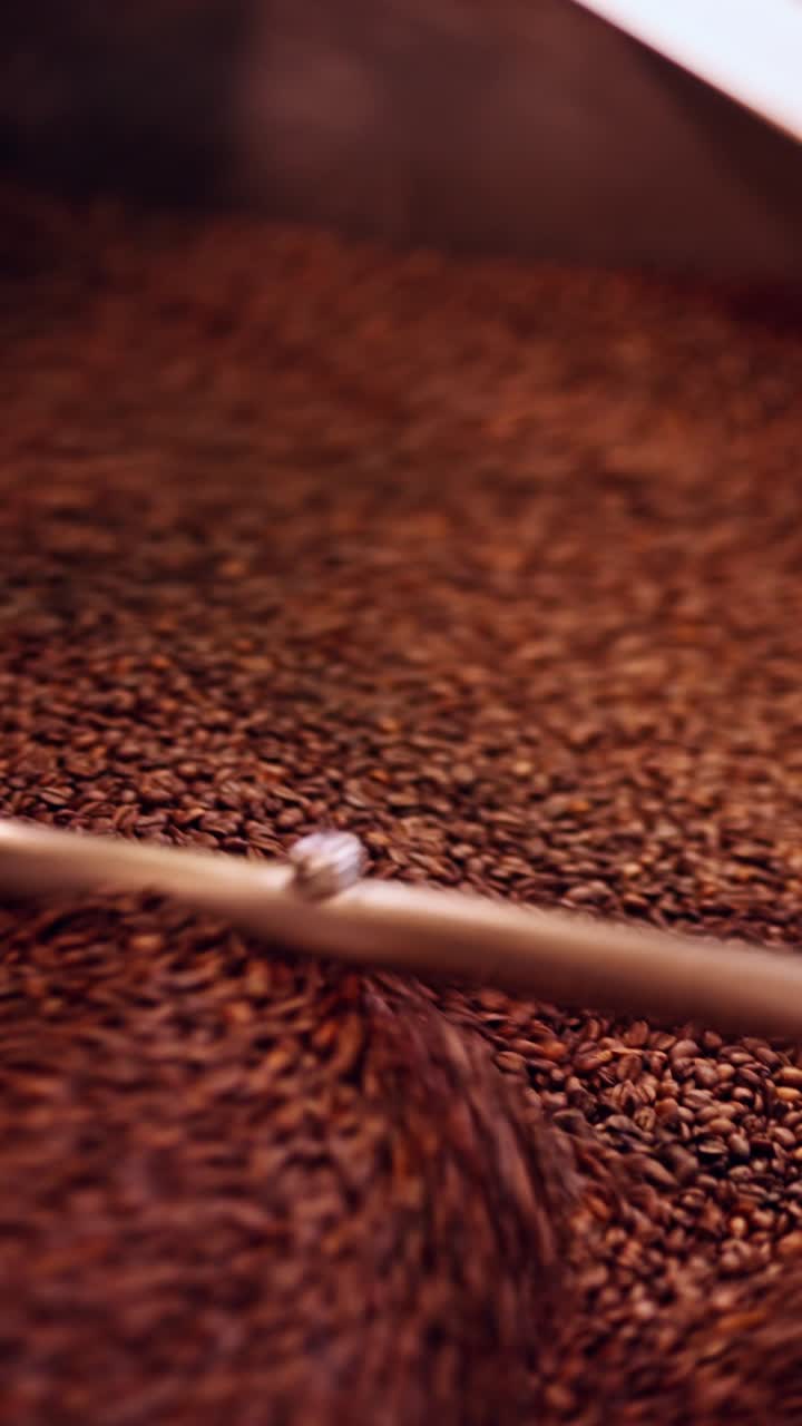 Primo piano verticale di chicchi di caffè appena tostati con ricca texture rosso-nera e profondità di campo ridotta. Perfetto per Reels, TikTok Shorts e branding premium per i social media