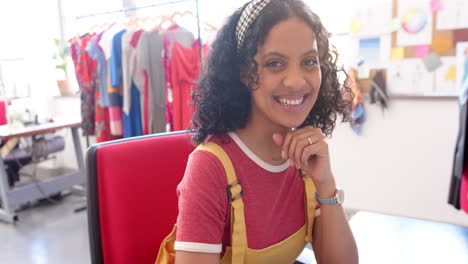 Biracial-female-fashion-designer-using-laptop-at-desk-in-studio,-slow-motion