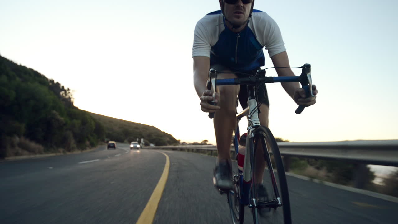 Uomo sano in bicicletta da strada all'aperto, ripresa fitness con steadicam.