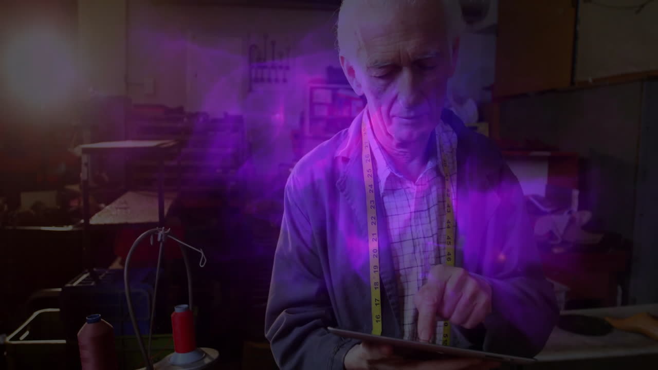 senior tailor tapping tablet in fashion tech workshop, projecting fabric chart, showing purple glow