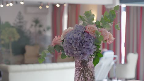 beautiful soft color flowers standing in modern apartment building, with the tv playing in the background