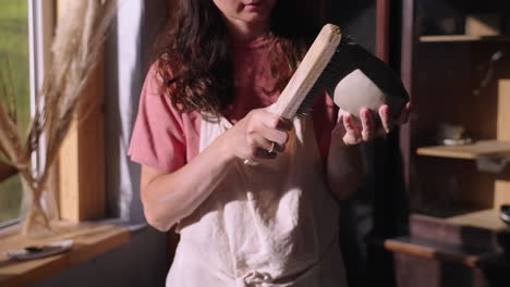 mujer limpiando un cuenco de arcilla hecho a mano