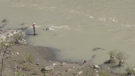 fisherman fishing with rod on a river with murky water in georgia