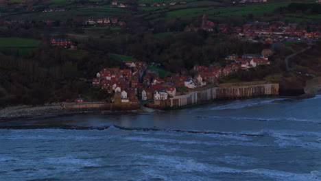 descending establishing drone shot of robin hood's bay at low tide morning