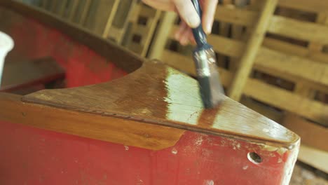 brushing varnish over plywood on fiberglass canoe bow