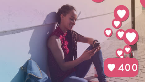 animation of heart icons over smiling biracial woman using smartphone