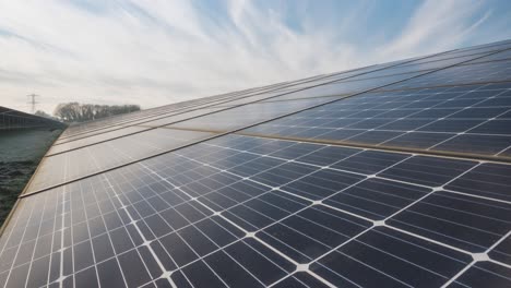 Zeitraffer-Des-Solarparks-Mit-Wolken,-Die-Auf-Sonnenkollektoren-Reflektieren