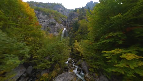 vuelo a través del bosque de colores otoñales hasta una cascada en el parque nacional theth en albania