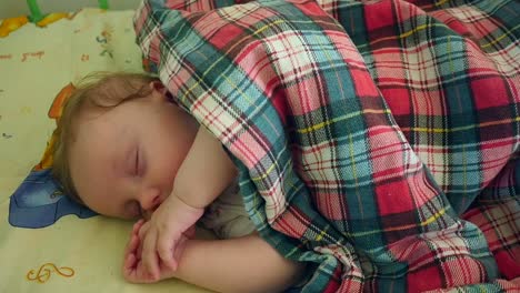 sleeping baby covered in the crib