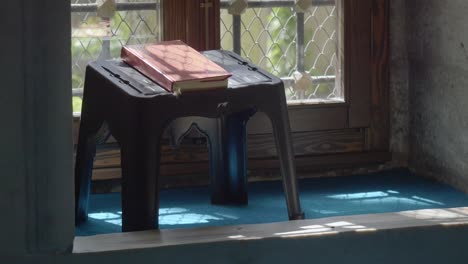 quran on a stand near a window