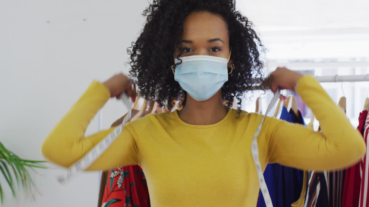 retrato de uma designer de moda feminina usando uma máscara facial com fita métrica ao redor do pescoço