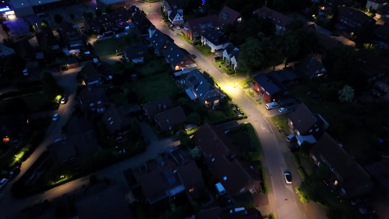 Blinking party lights in roofed patio in garden of house. Aerial top down shot. Night scene with lighting streetlights and parking cars in american neighborhood.