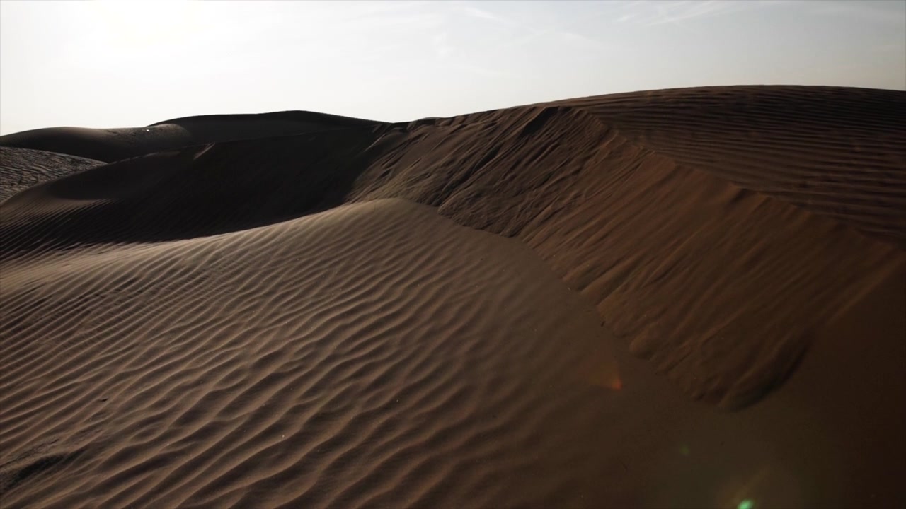 Paesaggio desertico mediorientale vicino a Dubai negli Emirati Arabi Uniti. Sabbia, strada nel deserto, tramonto, aerea, timelapse, sole, cielo, notte, guida, strada, Medio Oriente, pianta, arbusto, cespuglio, granello.
