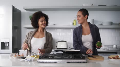 lesbian couple preparing breakfast in kitchen