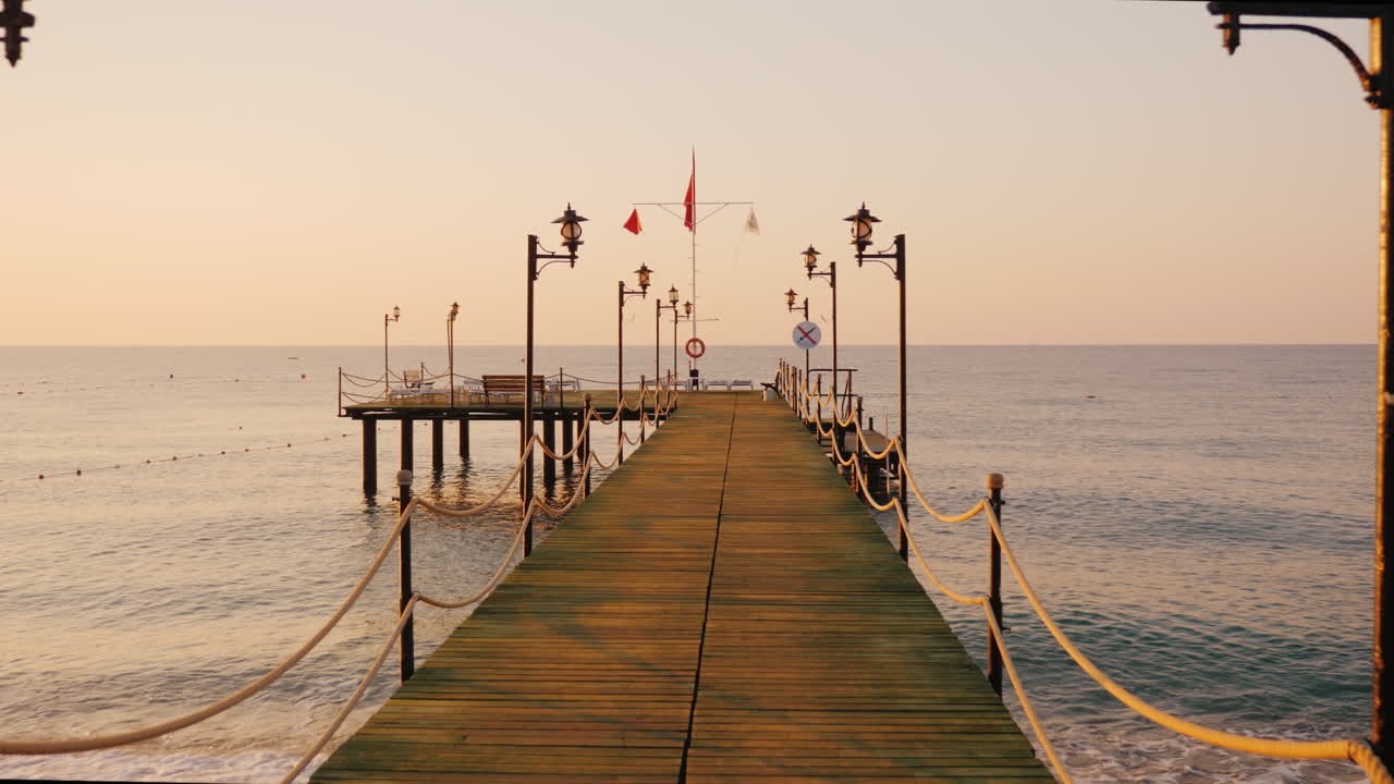 Passeggiata lungo il molo di legno verso il mare di primo mattino.