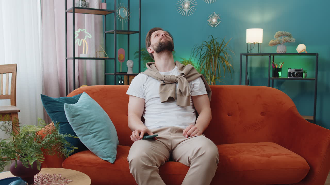 Repair work at neighbours concept irritated man at home cover ears with pillows annoyed by noise