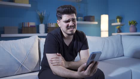 el hombre que mira el teléfono está molesto y emocional.