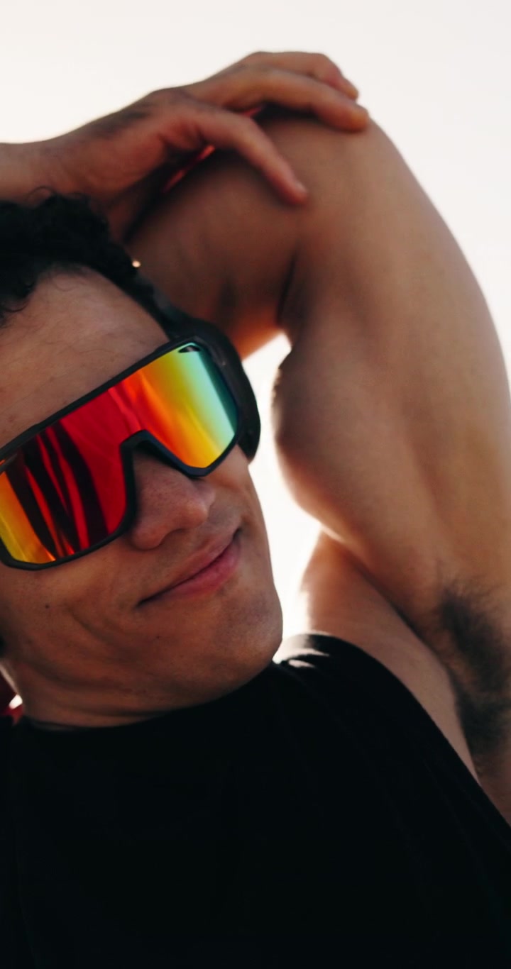 Young Man Wearing Sport Sunglasses and Headphones Exercising Outdoors