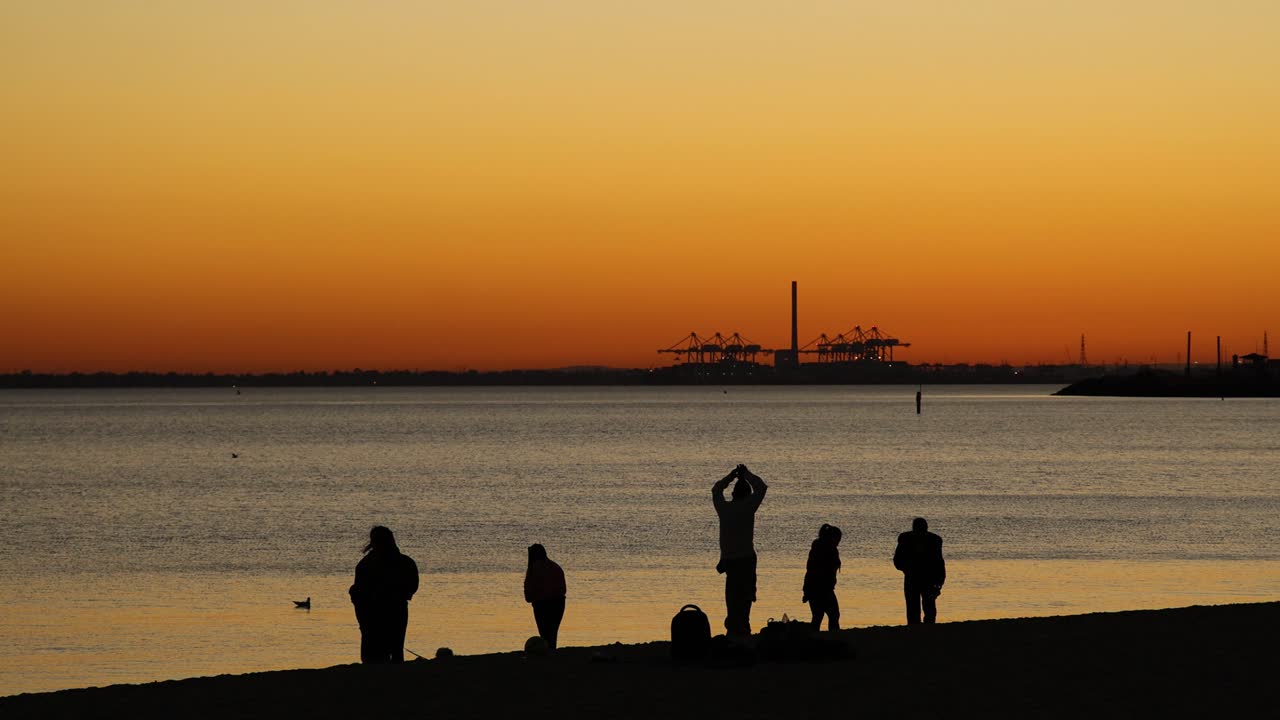 세인트 킬다 해변에서 해가 지는 것을 즐기는 사람들