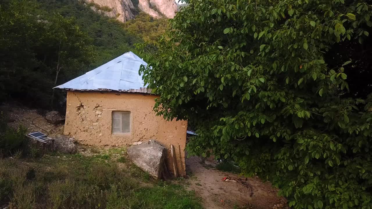 volar sobre una tradicional histórica gente local madera barro casa de arcilla en el clima de la montaña bosque en verano temporada de primavera en la puesta de sol hora de oro en un árbol verde prado campo colinas en el norte de irán
