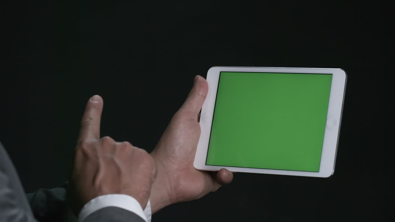 크로마 키를 가진 태블릿을 사용하는 사람
