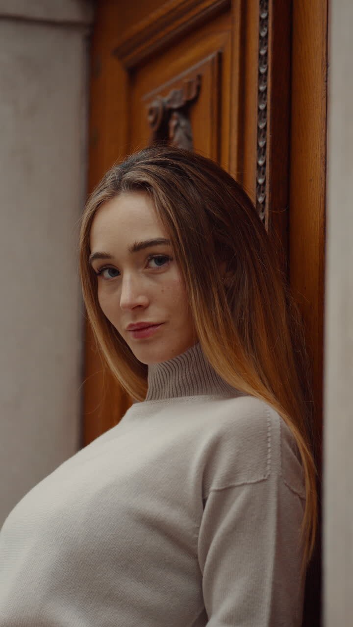 Woman in a Sweater Posing by a Wooden Door