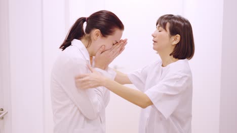 doctor crying receives a hug and support from her coworker