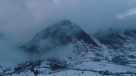 Drohne-Fliegt-Rückwärts-Durch-Die-Wolken-Und-Enthüllt-Die-Schneebedeckte-Bergkette-In-Ehmej