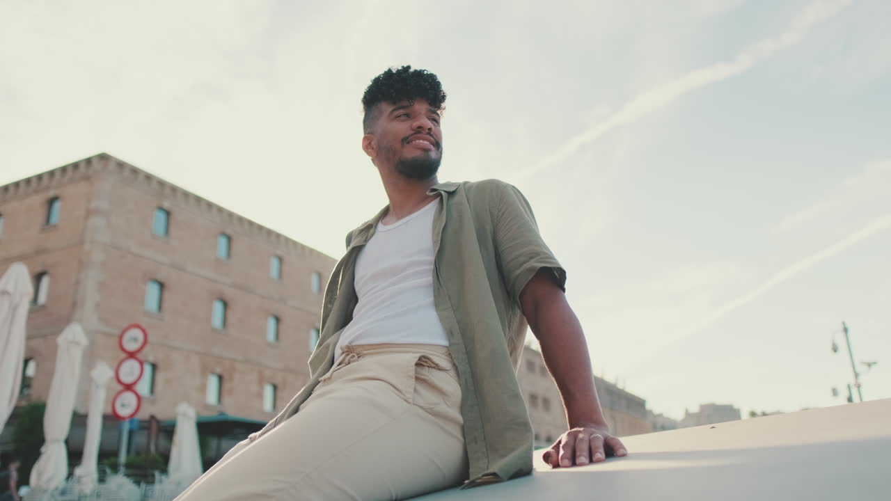 Young man sitting outdoors in urban setting