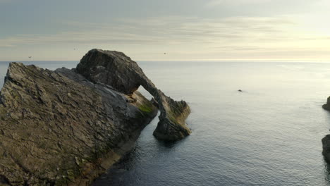 Una-Vista-Aérea-De-Bow-Fiddle-Rock-En-Portknockie-En-Una-Tranquila-Mañana-De-Verano