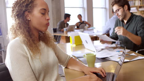 businesswoman using laptop at desk in office shot on r3d