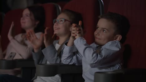 niños satisfechos aplaudiendo en el cine. tormenta de aplausos en el cine