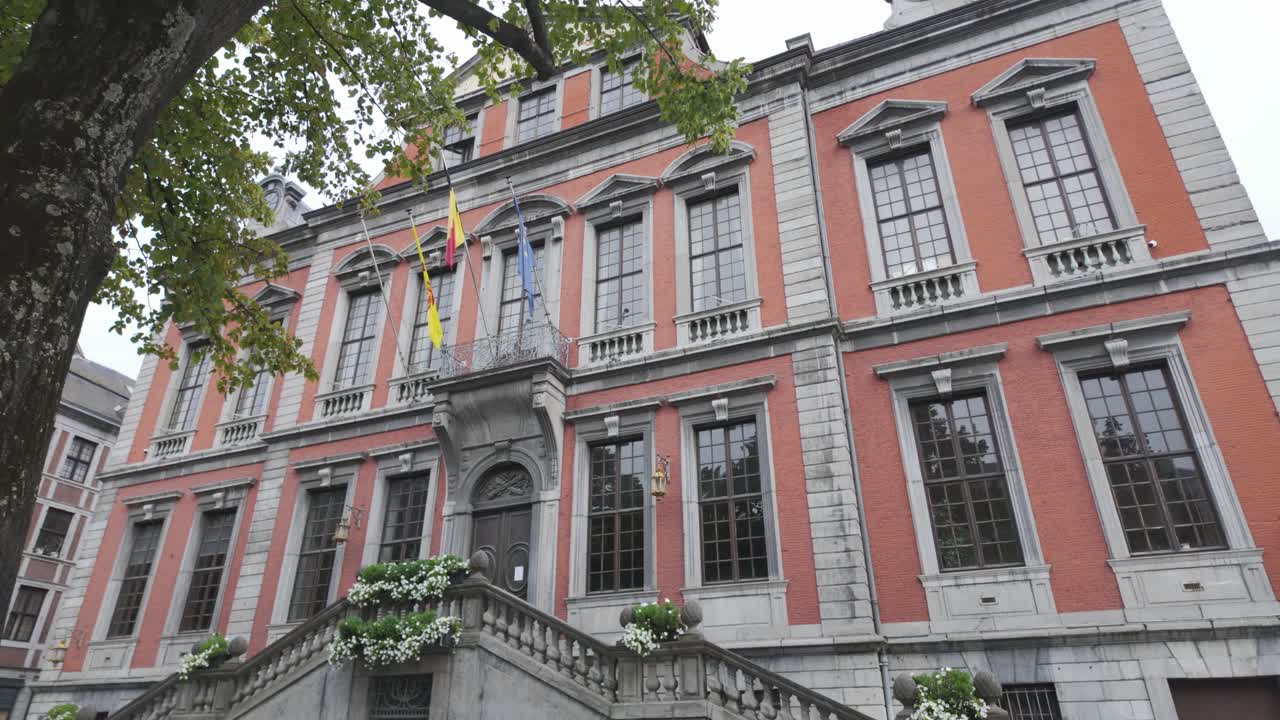 elegante ayuntamiento histórico en lieja con escaleras simétricas y vibrantes arreglos florales