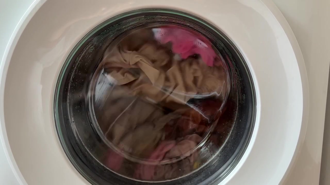Close up of clothes spinning inside a washing machine drum