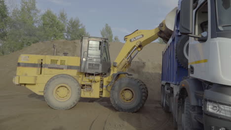 excavator loading dump truck with sand or gravel