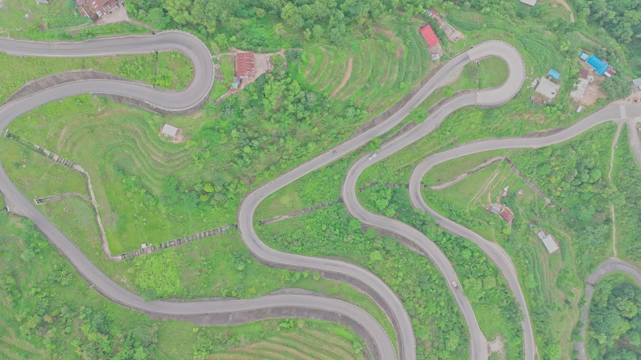 A smooth black-topped road cuts through the mountainous landscape, connecting remote areas and offering scenic views of nature, elevation, and rural infrastructure in Nepal’s highland regions.