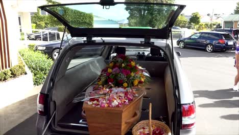 closeup shot of a funeral casket in a hearse or chapel or burial at cemetery