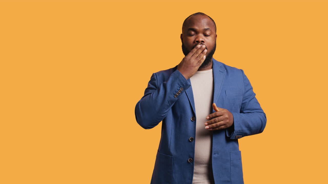 Man feeling exhausted and yawning, studio background
