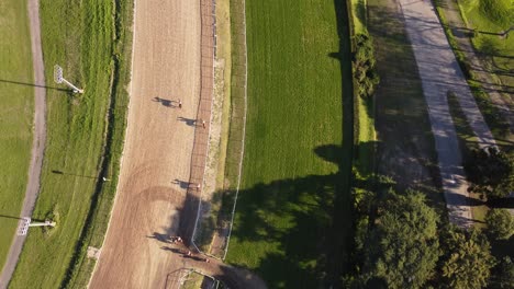 Aerial-top-down-view-of-race-horses-entering-the-race-course-track