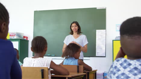 teacher asking elementary school kids a question in class