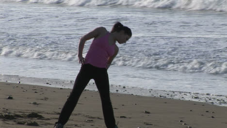 mujer estirándose en la playa