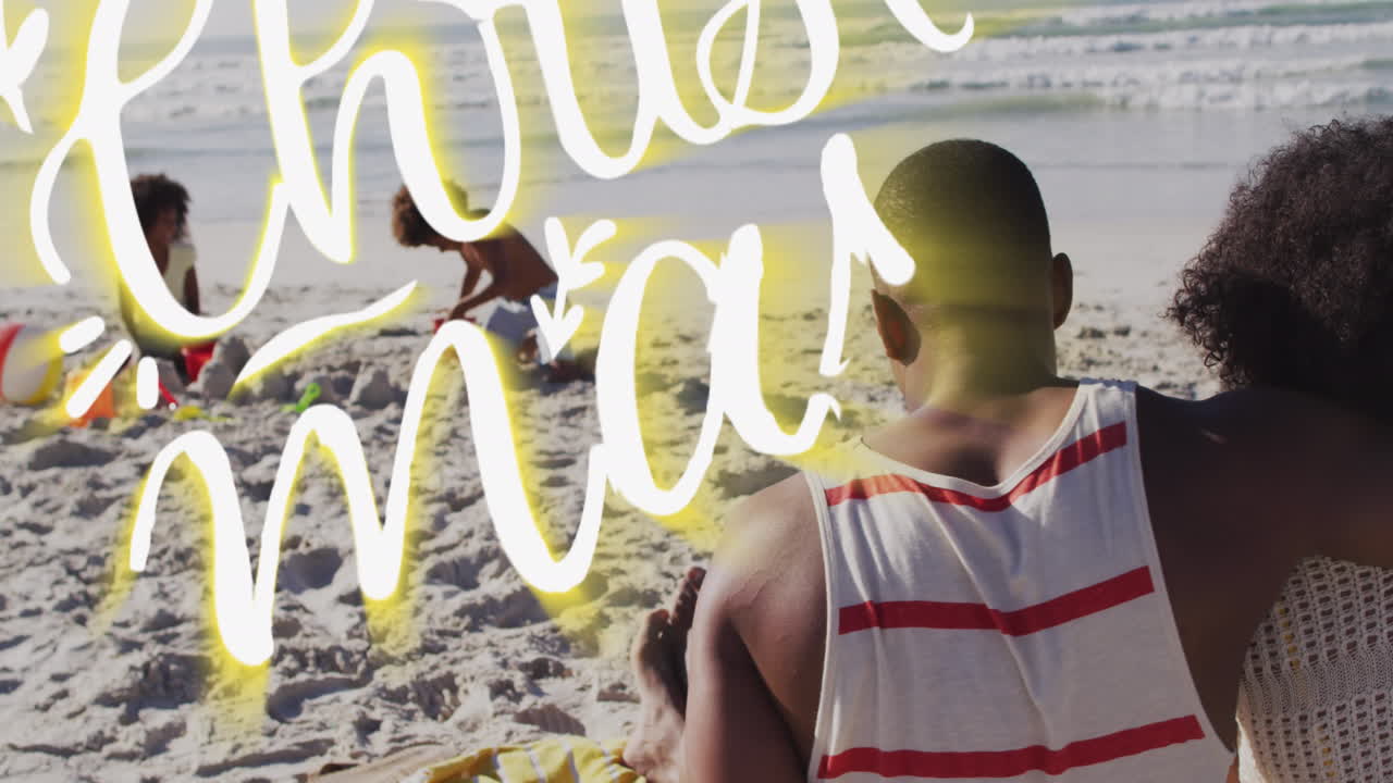 animación de saludos de navidad texto sobre pareja biracial con hijo e hija en la playa.